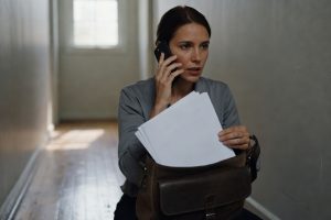 Femme rassemblant ses papiers avant de quitter discrètement son domicile