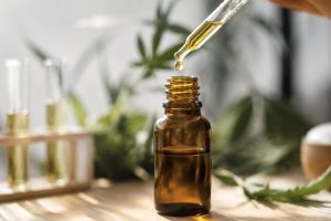 Flacon d'huile de CBD et pipette posés près d'un tube de prélèvement sanguin
