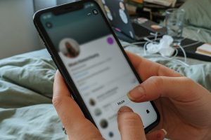 Mains tenant un smartphone en train de mettre en sourdine un profil.