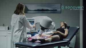 Séance de traitement des varices par ultrasons focalisés : praticienne, patiente allongée et tête robotisée Sonovein.